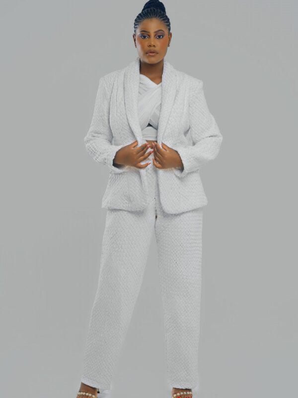 Le pantalon tailleur blanc Kroskel est l’essence même de l’élégance et de la modernité. Pensé pour accompagner les ambitions les plus hautes, il épouse la silhouette avec justesse, tout en offrant une liberté de mouvement absolue. Son tissage dense, signature de la maison Kroskel, apporte une profondeur subtile au blanc immaculé. Sa coupe droite, à la fois intemporelle et sophistiquée, s’adapte aussi bien aux tenues structurées qu’aux looks plus décontractés. Porté avec la veste assortie, il compose un ensemble d’une élégance redoutable. Associé à une pièce plus colorée, il devient un terrain d’expression, jouant avec les contrastes et les nuances pour révéler toute la richesse du style Kroskel. Ce pantalon peut être accessoirisé avec une ceinture inspirée des nœuds Kroskel, symbole de la complexité et de la puissance féminine. Léger, fluide et parfaitement coupé, il accompagne la femme Kroskel dans les moments les plus stratégiques de sa vie, en lui offrant une silhouette impeccable et un confort inégalé. Un indispensable du vestiaire contemporain, pensé pour celles qui avancent avec audace et élégance.