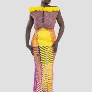 Plus qu’un vêtement, cette robe est une œuvre d’art, un dialogue entre force et couleur, entre tradition et modernité. Conçue pour la femme Kroskel qui avance avec assurance, elle incarne la puissance de celles qui tissent ensemble un avenir lumineux. Le buste, minutieusement travaillé, est inspiré des cases africaines et de leurs toits de paille. Les nœuds délicatement tissés viennent se poser comme des symboles de protection et d’ancrage, tandis que la couleur jaune éclatante illumine l’ensemble, porteuse d’espoir et de renouveau. Sa coupe majestueuse met en valeur la silhouette avec une jupe montante qui épouse la taille et vient se fixer au buste grâce à de sublimes petits boutons, créant une transition harmonieuse entre les textures et les volumes. Son dos nu et sa longue fente dans le dos apportent une touche de sensualité et de liberté, offrant une aisance parfaite à chaque mouvement. Réalisée en plus de 100 heures de travail, cette robe est un hommage au savoir-faire artisanal d’exception. Elle est destinée à celles qui osent, qui inspirent et qui laissent une empreinte indélébile sur leur passage.