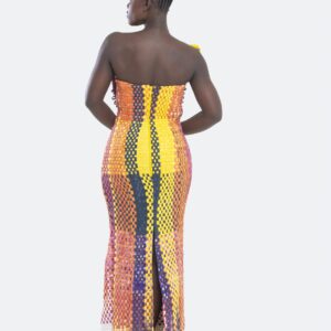Plus qu’un vêtement, cette robe est une œuvre d’art, un dialogue entre force et couleur, entre tradition et modernité. Conçue pour la femme Kroskel qui avance avec assurance, elle incarne la puissance de celles qui tissent ensemble un avenir lumineux. Le buste, minutieusement travaillé, est inspiré des cases africaines et de leurs toits de paille. Les nœuds délicatement tissés viennent se poser comme des symboles de protection et d’ancrage, tandis que la couleur jaune éclatante illumine l’ensemble, porteuse d’espoir et de renouveau. Sa coupe majestueuse met en valeur la silhouette avec une jupe montante qui épouse la taille et vient se fixer au buste grâce à de sublimes petits boutons, créant une transition harmonieuse entre les textures et les volumes. Son dos nu et sa longue fente dans le dos apportent une touche de sensualité et de liberté, offrant une aisance parfaite à chaque mouvement. Réalisée en plus de 100 heures de travail, cette robe est un hommage au savoir-faire artisanal d’exception. Elle est destinée à celles qui osent, qui inspirent et qui laissent une empreinte indélébile sur leur passage.