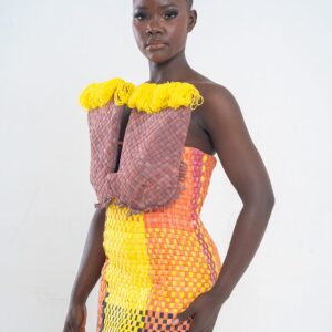 Plus qu’un vêtement, cette robe est une œuvre d’art, un dialogue entre force et couleur, entre tradition et modernité. Conçue pour la femme Kroskel qui avance avec assurance, elle incarne la puissance de celles qui tissent ensemble un avenir lumineux. Le buste, minutieusement travaillé, est inspiré des cases africaines et de leurs toits de paille. Les nœuds délicatement tissés viennent se poser comme des symboles de protection et d’ancrage, tandis que la couleur jaune éclatante illumine l’ensemble, porteuse d’espoir et de renouveau. Sa coupe majestueuse met en valeur la silhouette avec une jupe montante qui épouse la taille et vient se fixer au buste grâce à de sublimes petits boutons, créant une transition harmonieuse entre les textures et les volumes. Son dos nu et sa longue fente dans le dos apportent une touche de sensualité et de liberté, offrant une aisance parfaite à chaque mouvement. Réalisée en plus de 100 heures de travail, cette robe est un hommage au savoir-faire artisanal d’exception. Elle est destinée à celles qui osent, qui inspirent et qui laissent une empreinte indélébile sur leur passage.